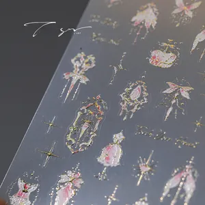 Detail of bronzing nail art stickers featuring royal crowns and vintage dress patterns