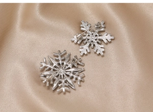 Detail view of the silver snowflake brooch back showing pin clasp and matte texture