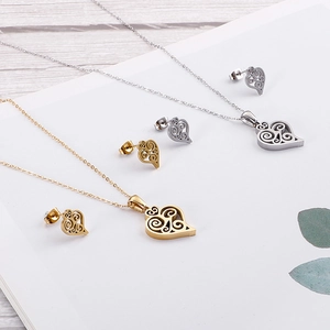Hollow heart pattern jewelry set with gold and silver necklaces and earrings on white