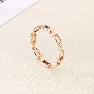 Macro shot of minimalist rose gold hollow chain link ring showing fine metal texture