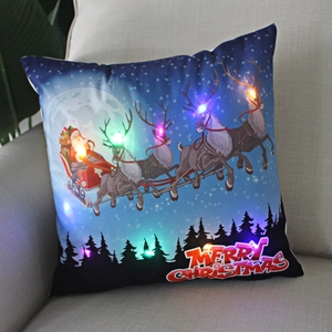 Detail of Christmas LED pillow showing Santa on a sleigh with festive glowing lights