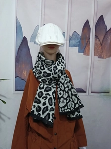 Detail of black and white leopard pattern thick scarf with fringe on model