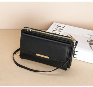 Close-up of black crossbody phone wallet with double zippers and gold metal hardware