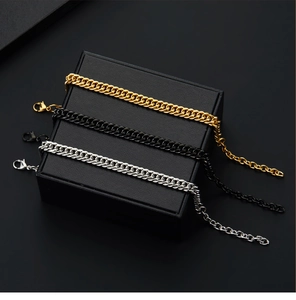 Close-up of dual-row Cuban link bracelets in gold, black, and silver stainless steel
