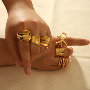 Minimalist gold irregular stainless steel rings with bow and twisted designs on a hand