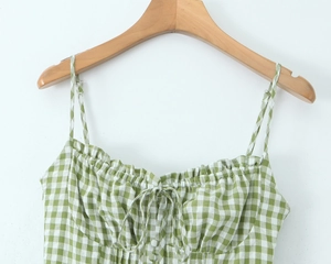Detail view of the green and white gingham floral top with smocked chest and lace-up bow