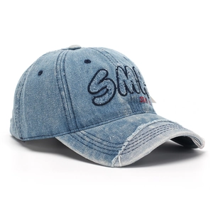 Close-up of vintage light blue denim baseball cap with 3D Smile embroidery and distressed brim