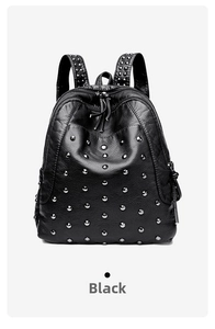 Close-up of black litchi grain leather backpack featuring decorative silver studs and hardware