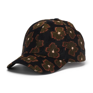 Detail of black baseball cap featuring dark green floral prints and red embroidered edges