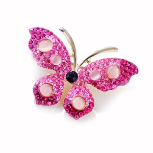 Detailed view of butterfly brooch with rose red rhinestones and pink cat eye stones