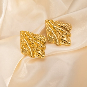 Vintage gold irregular textured geometric stud earrings on elegant champagne silk