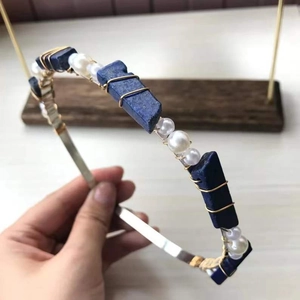 Detail of handcrafted gold headband with raw blue crystals and white pearls