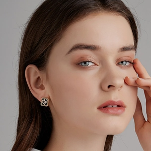 Gros plan de boucles d'oreilles carrées dorées vintage avec incrustation noire et cristaux