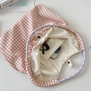 Détail du sac cabas en toile à carreaux rouges avec anses en corde et poche intérieure