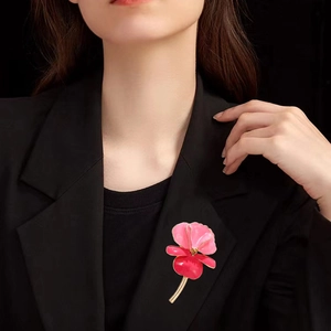 Vintage enamel iris flower brooch with pink and crimson petals on black suit jacket