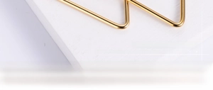 Extreme close-up of golden triangular titanium steel earring with smooth polished finish