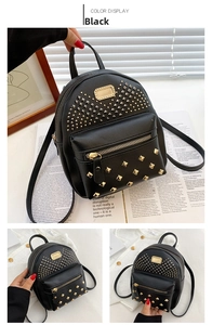 Detail of black PU leather mini backpack with gold rivets and front zipper pocket