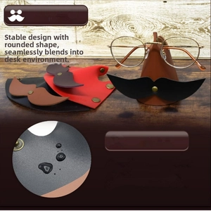 Macro shot of stylish faux leather glasses stand with mustache-shaped metal clip