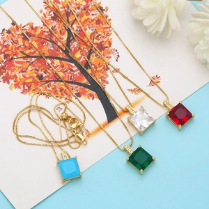 Détail de colliers en zircon carré en bleu, émeraude, blanc et rubis sur chaîne dorée
