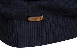 Detail of navy knit sweater showing cable stitch pattern and brown leather logo tag