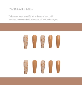 Detail of long coffin press-on nails with beige heart patterns and rhinestones