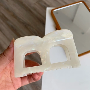 Detail of white pearlescent marble letter A acetate hair claw clip with large grip