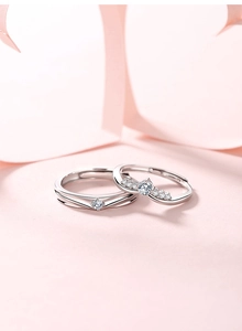 Macro shot of silver couples rings featuring a V-shaped band and a crown set with zircons