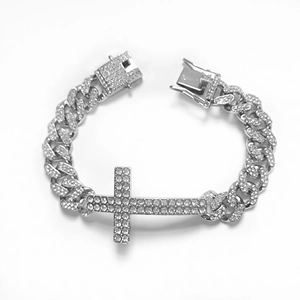 Close-up of iced-out silver Cuban chain bracelet featuring a diamond-set cross charm
