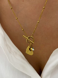 Close-up of golden heart pendant with Mom engraving and rhinestone on OT buckle necklace