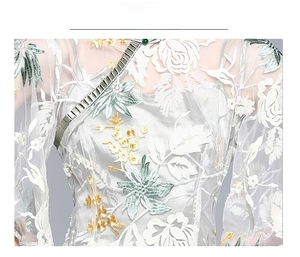 Detail of floral embroidery and sequins on a silver mesh cheongsam dress fabric