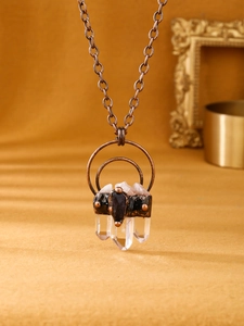 Detail of vintage necklace with three hexagonal white quartz pillars and antique bronze chain