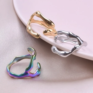 Detail of three liquid metal rings in gold, silver and rainbow iridescent plating