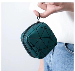 Detail of green geometric pattern mini pouch with black zipper and ring handle