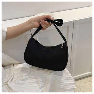 Detail of black corduroy baguette bag showing vertical rib texture and silver zipper pull
