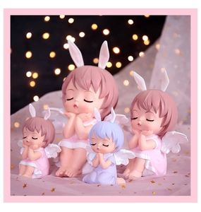 Four resin angel figurines with rabbit ears and tutus against a dreamy pink background