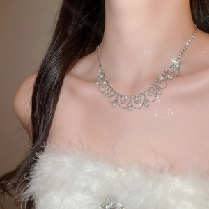Close-up of pearl and rhinestone fringe necklace showing elegant lace tassel detail