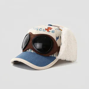 Detail of kids baseball cap with aviator goggles, earflaps, and cute dinosaur print