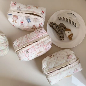 Detailed close-up of quilted cotton cosmetic bags with cute animal prints and floral patterns