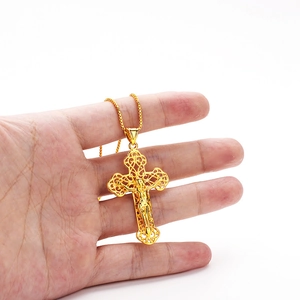 Close-up of gold-plated crucifix cross pendant with Jesus figure on a box chain necklace