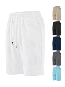 Detailed close-up of textured waffle knit fabric and drawstring waistband on beach shorts