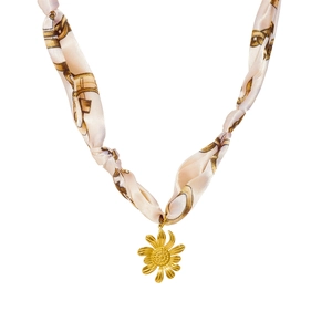 Détail du collier en ruban de soie beige avec pendentif tournesol doré et chaîne