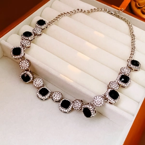 Détail du collier avec pierres noires carrées et zircons dans une boîte à bijoux en velours