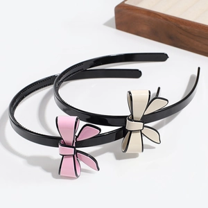 Detail of black non-slip headbands with large pink and beige cream style bows