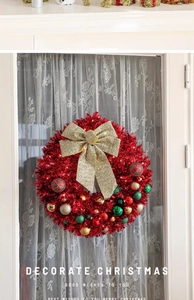 Detail of 45cm red tinsel Christmas wreath with golden bow and colorful baubles