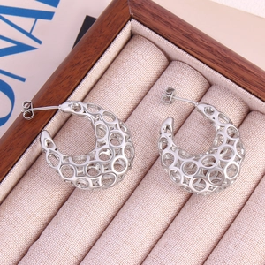 Minimalist silver hollow geometric C-shaped hoop earrings on a luxury wooden jewelry box