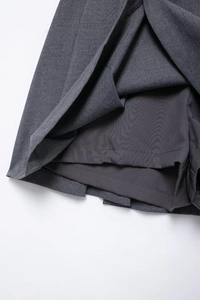 Detailed view of the dark grey pleated skirt showing the anti-exposure inner lining layer