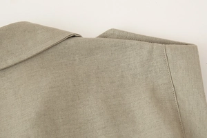 Macro detail of the V-neck collar and breathable linen fabric texture on the dress