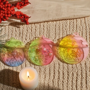 Tres adornos navideños de resina degradada con grabado sobre fondo de punto suave