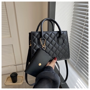 Close-up of black quilted shoulder bag with matching coin purse and stylish light shadows