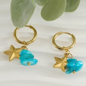 Golden star earrings with blue natural stone charms on white wavy background